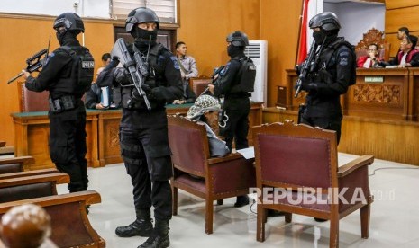 Petugas kepolisian bersenjata lengkap menjaga terdakwa kasus dugaan serangan teror bom Thamrin dengan terdakwa Oman Rochman alias Aman Abdurrahman saat menjalani sidang lanjutan di Pengadilan Negeri Jakarta Selatan, Jumat (25/5). 