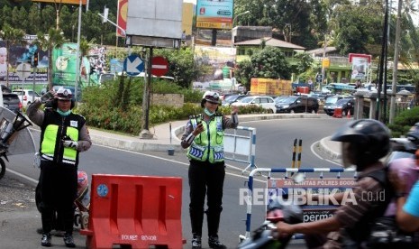 Petugas kepolisian bersiap melakukan rekayasa lalu lintas untuk mencegah kemacetan kendaraan menuju Puncak, Bogor, Jawa Barat.  (Republika/Rakhmawaty La'lang)