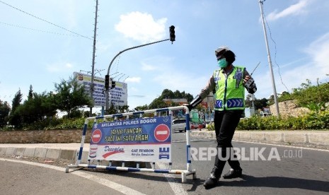 Petugas kepolisian bersiap untuk melakukan rekayasa lalulintas untuk mencegah kemacetan kendaraan menuju puncak yang terjebak kemacetan di Simpang Gadog, Bogor, Jawa Barat, Jumat (6/5).  (Republika/Rakhmawaty La'lang)