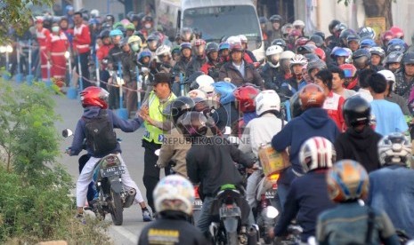 Petugas kepolisian berusaha mengatur kemacetan pemudik motor yang melintas di jalur alternatif motor di Lamaran, Karawang, Jawa Barat, Selasa (14/7).    (Republika/Agung Supriyanto)