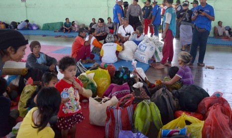 Petugas kepolisian dan BPBD mendata para pengungsi Gunung Agung yang baru tiba di GOR Swecapura, Kabupaten Klungkung, Bali, Kamis (21/9). 