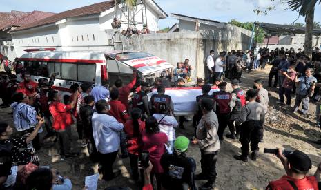 Petugas kepolisian dan kerabat mengangkat peti jenazah almarhum Brigadir Nofriansyah Yosua Hutabarat atau Brigadir J saat pemakaman kembali setelah autopsi ulang di Sungai Bahar, Muarojambi, Jambi, Rabu (27/7/2022). Autopsi ulang yang berlangsung selama enam jam itu dilakukan atas permintaan keluarga dalam mencari keadilan dan pengungkapan kasus. 