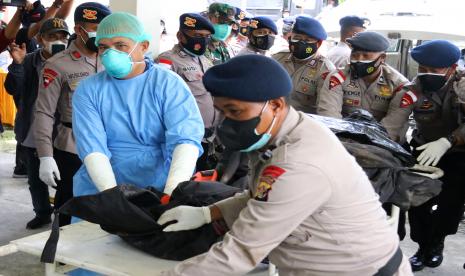 Petugas kepolisian dan petugas medis membawa kantong berisi jenazah teknisi tower telekomunikasi PT Palapa Timur Telematika (PTT) setibanya di RSUD Timika, Papua, Senin (7/3/2022). Tim Operasi Damai Cartenz 2022 berhasil mengevakuasi delapan korban penembakan yang dilakukan oleh Kelompok Kriminal Bersenjata (KKB) di Kampung Jenggeran, Distrik Beoga Barat, Kabupaten Puncak, Papua pada Rabu (2/3/2022).