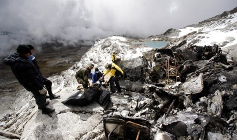  Petugas kepolisian dan petugas penyelamat melakukan evakuasi korban kecelakaan helikopter di Gunung Mama Rosa di Ocongate, Peru, 10 Juni 2012. 