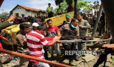 Petugas kepolisian dibantu warga melakukan evakuasi korban kecelakaan tabrakan beruntun di Jalan Raya Sukabumi, Kecamatan Gekbrong, Kabupaten Cianjur Jawa Barat, Sabtu (30/7).