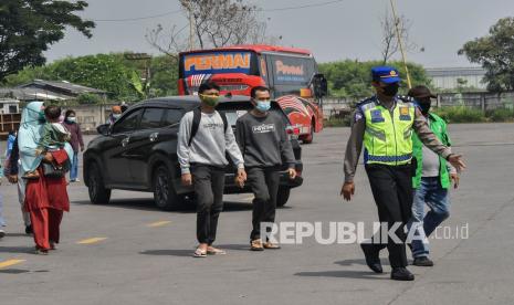 Petugas Kepolisian (kanan) mengarahkan sejumlah pemudik untuk mengikuti rapid antigen di Terminal Kalijaya, Cikarang, Kabupaten Bekasi, Sabtu (24/4/2021). Dari hasil pemeriksaan kesehatan dan sosialisasi larangan mudik jelang lebaran yang dilaksanakan Satuan Lalu Lintas (Satlantas) Polres Metro Bekasi terdapat dua pemudik yang positif COVID-19. 