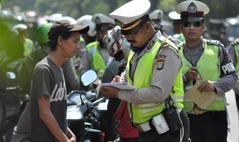 Petugas kepolisian lalu lintas menindaki seorang pengendara sepeda motor pada Operasi Zebra Jaya 2012 di Kawasan Pasar Rebo, Jakarta Timur, Jumat (30/11).