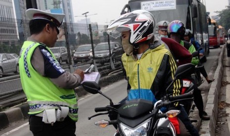   Petugas kepolisian melaksanakan operasi penertiban di jalur Bus Transjakarta kawasan Jalan MT. Haryono, Jakarta Selatan, Rabu (26/3).  (Republika/Yasin Habibi)