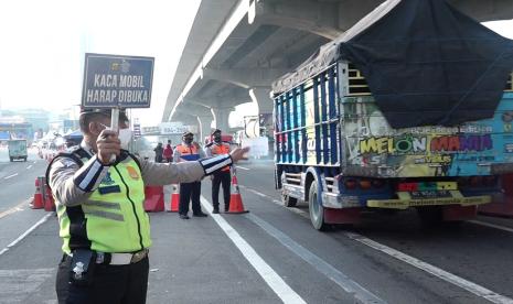 Petugas kepolisian melakukan penyekatan terhadap kendaraan di Tol Jakarta-Cikampek untuk mengantisipasi para pemudik.