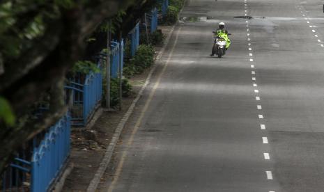 Petugas Kepolisian melintas di Jalan Sudirman, Pekanbaru, Riau, Senin (27/4/2020). Satuan Lalu Lintas Kepolisian Resor Kota Pekanbaru menambah kebijakan jam penutupan jalan-jalan utama di Kota Pekanbaru yang tadinya dari pukul 20.00 hingga 05.00 dinihari menjadi pukul 20.00 hingga 14.00 untuk memaksimalkan pelaksanaan Pembatasan Sosial Berskala Besar (PSBB). 