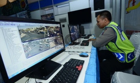  Petugas kepolisian memantau jalur arus mudik melalui tayangan kamera cctv di Pos pantauan arus mudik yang menyatu dengan Pos Polisi Cikopo, Cikampek, Jawa Barat, Jumat (10/7).