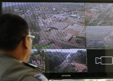 Petugas kepolisian memantau sejumlah titik di jalur Nagreg, Kabupaten Bandung, Jawa Barat, Ahad (28/8), melalui monitor yang menerima gambar dari kamera CCTV. 