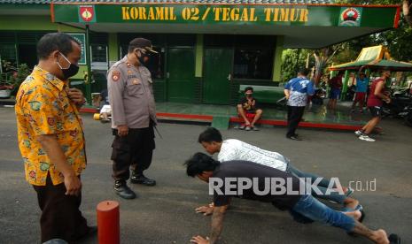 [ilustrasi] Petugas kepolisian memberi sanksi push up kepada warga yang tidak mengenakan masker saat razia yustisi protokol kesehatan.