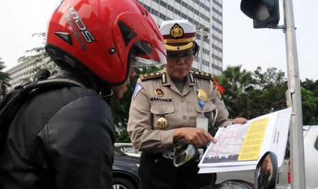 Petugas kepolisian memberikan sosialisasi tentang pengalihan arus lalu lintas saat hari pengumuman rekapitulasi suara Pilpres 2014-2019 di kawasan Bundaran HI, Jakarta, Jumat (18/7). 