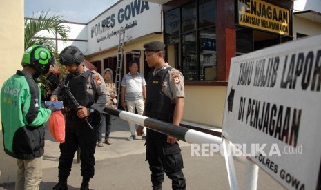 Petugas kepolisian memeriksa barang pengemudi ojek online yang akan masuk mengantar pesanan di Polres Kabupaten Gowa, Sulawesi Selatan, Rabu (13/11/2019). 