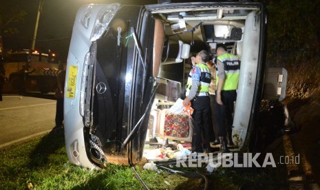 Petugas kepolisian memeriksa bis saat evakuasi kecelakaan bus pariwisata di tanjakan Emen, Kabupaten Subang, Sabtu (10/2).