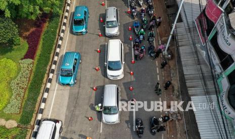 Petugas kepolisian memeriksa dokumen dan persyaratan pengendara yang melintasi pos penyekatan PPKM Darurat di Jalan Raya Lenteng Agung, Jakarta, Rabu (7/7/2021). Kapolda Metro Jaya Irjen Pol Fadil Imran menyatakan adanya penurunan mobilitas masyarakat di Jakarta sejak diterapkannya Pemberlakuan Pembatasan Kegiatan Masyarakat (PPKM) Darurat.