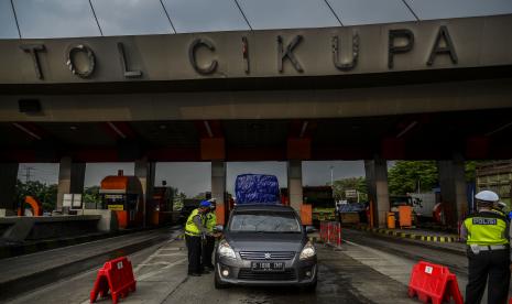 Petugas Kepolisian memeriksa dokumen pengendara yang melintas di check point penyekatan arus mudik Tol Cikupa, Tanggerang.