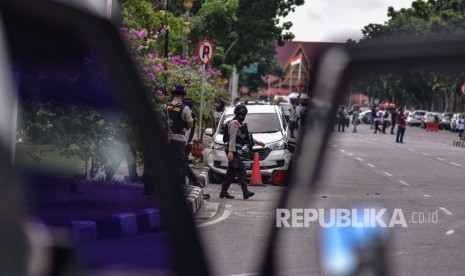 Petugas kepolisian memeriksa mobil minibus yang digunakan pelaku teror untuk menyerang Polda Riau, di Pekanbaru, Riau, Rabu (16/5).