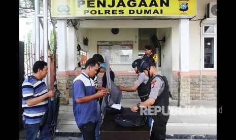 Petugas kepolisian memeriksa semua barang bawaan pengunjung di Markas Kepolisian Resor (Mapolres) Dumai di kota Dumai, Dumai, Riau, Senin (14/5). 