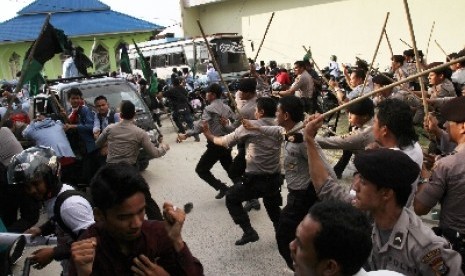 Petugas kepolisian memukul mundur pengunjukrasa yang ingin menguasai kantor RRI di halaman kantor Radio Republik Indonesia (RRI) di Pekanbaru, Riau,