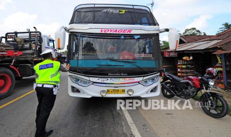 Petugas kepolisian menahan laju bus antarkota antarprovinsi (AKAP) rute Jakarta-Medan saat penyekatan pemudik di Jalan Lintas Timur Sumatera, Mestong, Muarojambi, Jambi, Selasa (4/5/2021). Polda Jambi bersama personel gabungan dari TNI dan instansi terkait mulai memperketat penyekatan arus mudik di sembilan titik jalur masuk darat, laut, dan udara daerah itu terkait larangan mudik Lebaran 2021 guna mencegah penularan COVID-19. 