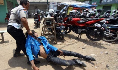   Petugas kepolisian mengamankan seorang mahasiswa saat aksi demonstrasi di Kampus Universitas Pamulang, Pamulang, Tangerang Selatan, Kamis (19/10). (Muhammad Iqbal/Antara)