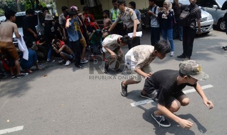 Petugas kepolisian mengamankan suporter Persija The Jak di Polda Metro Jaya, Jakarta, Ahad (18/10).  (Republika/Yasin Habibi) 