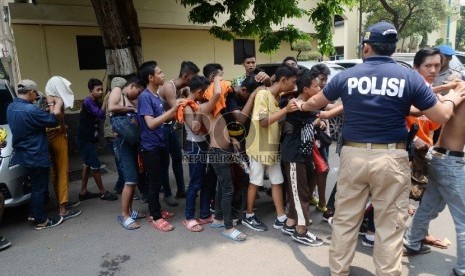 Petugas kepolisian mengamankan suporter Persija The Jak di Polda Metro Jaya, Jakarta, Ahad (18/10).  (Republika/Yasin Habibi) 