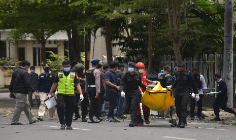 Petugas kepolisian mengangkat kantong jenazah berisi bagian tubuh dari terduga pelaku bom bunuh diri di depan Gereja Katedral Makassar, Sulawesi Selatan, Ahad (28/3/2021). Bagian tubuh jenazah tersebut selanjutnya dibawa ke Rumah Sakit Bhayangkara Makassar untuk diidentifikasi.