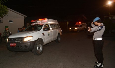 Petugas kepolisian mengarahakan mobil ambulans yang mengangkut Jenazah korban jatuhnya helikopter milik TNI di Poso saat tiba di Rumah Sakit Bhayangkara Palu, Sulawesi Tengah, Senin (21/3).