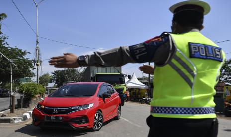 Petugas Kepolisian mengarahkan kendaraan pribadi untuk putar balik saat melintas di jalan Raya Pacing Bekasi, Jawa Barat, Sabtu (23/5/2020). Pemeriksaan tersebut dilakukan untuk mengantisipasi gelombang pemudik yang akan melintasi jalur Pantura Karawang menuju Jawa Tengah.