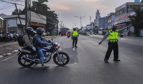 Petugas kepolisian mengarahkan pemudik bersepeda motor untuk berbalik arah di daerah Bulak Kapal, Bekasi, Jawa Barat, Ahad (31/5/2020). Kegiatan tersebut sebagai upaya penyekatan pemudik motor yang akan memasuki wilayah Bekasi.