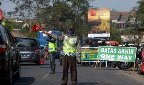 Petugas kepolisian mengatur antrean kendaraan pemudik di jalur Nagrek-Limbangan, Jawa Barat, Selasa (14/7).    (Republika/Rakhmawaty La'lang)