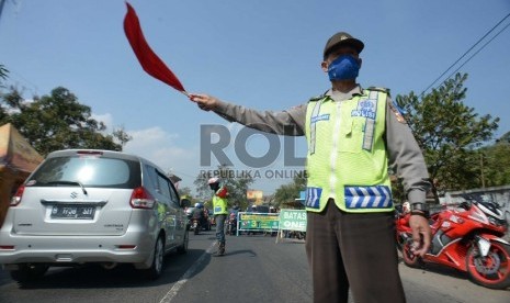 Petugas kepolisian mengatur antrean kendaraan pemudik di jalur Nagrek -Limbangan, Jawa Barat, Selasa (14/7).    (Republika/Rakhmawaty La'lang)