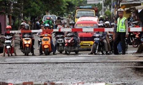 Petugas kepolisian mengatur lalu lintas di Pintu Perlintasan KA Pesanggerahan ketika diberlakukan sistem satu arah, Bintaro, Jakarta Selatan, Senin (23/12).  (Republika/Yasin Habibi)