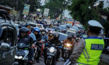 Petugas kepolisian mengatur lalu lintas kendaraan dari arah Garut, Tasikmalaya dan Sumedang menuju Kota Bandung di Cinunuk, Kabupaten Bandung, Jawa Barat, Ahad (23/8/2020). Satlantas Polresta Bandung menyatakan puncak arus balik libur panjang Tahun Baru Islam terjadi pada Minggu (23/8) dari arah kawasan wisata favorit di berbagai kota di Jawa Barat.