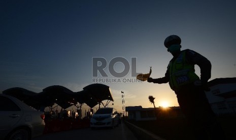  Petugas kepolisian mengatur lalu lintas ribuan kendaraan terjebak kemacetan sepanjang 38 Km dari Km 169 Ruas Jalan Tol Cipali hingga Km 207 ruas Jalan Tol Palikanci, Jawa Barat, Rabu (15/7). 