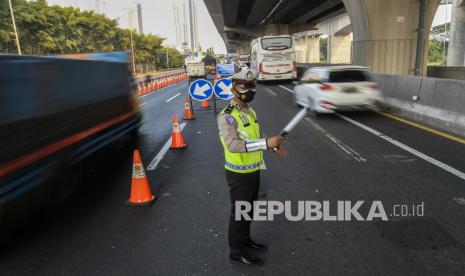 Petugas Kepolisian mengatur lalu lintas saat penyekatan di Tol Jakarta-Cikampek di KM 31, Cikarang, Kabupaten Bekasi, Jawa Barat, Sabtu (17/7/2021). Penyekatan tersebut untuk mengantisipasi lonjakan lalu lintas jelang hari libur Idul Adha dari tanggal 16-22 Juli 2021 dan juga mendukung pemerintah dalam melaksanakan Pemberlakuan Pembatasan Kegiatan Masyarakat (PPKM) Darurat guna mencegah penyebaran virus COVID-19. 