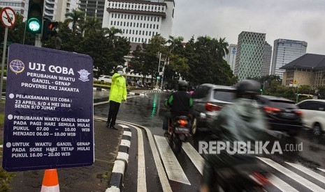 Petugas Kepolisian mengatur lalu lintas saat sistem ganjil genap di Jalan Medan Merdeka Barat, Jakarta