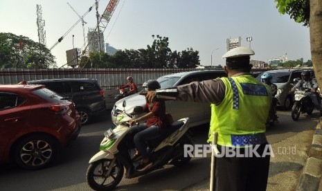 Petugas kepolisian mengatur rekayasa lalu lintas di Jalan Mampang, Jakarta Selatan, Senin (24/7).