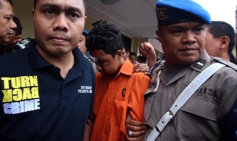 Petugas kepolisian mengawal seorang tersangka kasus pembunuhan Roy Mando Sah Siregar (20) saat gelar kasus di Mapolresta Medan, Sumatera Utara, Selasa (3/5). 