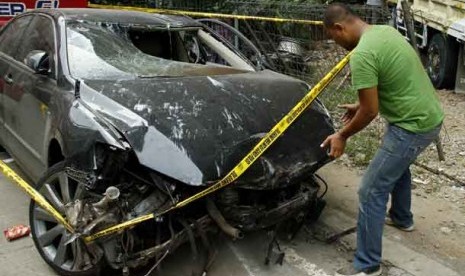 Petugas kepolisian mengecek kondisi mobil Camry bernopol B 1596 KF yang ringsek di Halaman Pos Polisi Ring Road, Jagakarra, Jakarta Selatan, Ahad (31/3).