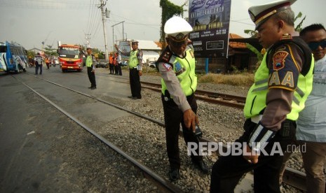 Perlintasan KA di wilayah PT KAI Daop 5 yang belum dijaga, masih cukup banyak.Tampak petugas kepolisian memeriksa rel saat evaluasi dan sosialisasi tertib lalu lintas di perlintasan sebidang palang pintu kereta api (KA) Tirus, Tegal, Jawa Tengah, Selasa (17/9/2019).