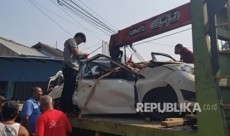 Petugas kepolisian mengevakuasi bangkai mobil saat terjadi kecelakaan maut antara truk pengangkut tanah dengan minibus daihatsu sigra yang hancur tak terbentuk akibat tertindih badan truk di Karawaci, Tangerang, Banten, Kamis (1/8/2019). 