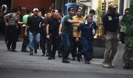 Petugas kepolisian mengevakuasi sejumlah karyawan saat terjadi penyerangan yang dilakukan sejumlah teroris ke beberapa gedung dan pos polisi di Jakarta, Kamis (14/1). 