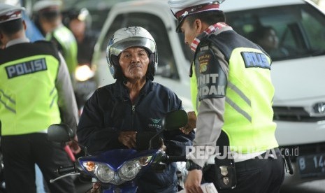   Petugas Lantas (lalu lintas Polda Metro Jaya)  menertibkan pelanggar lalu lintas di jalan Cempaka Putih, Jakarta Pusat, Rabu (4/10). 