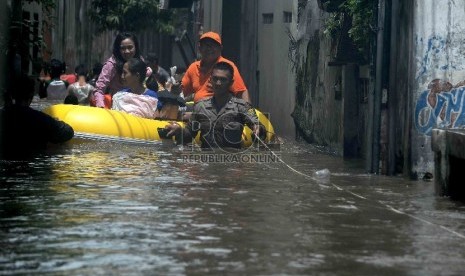 Petugas kepolisian menggunakan perahu karet mengevakuasi warga yang rumahnya terendam banjir di Petogogan, Jakarta Selatan, Selasa (10/2).(Republika/Agung Supriyanto)