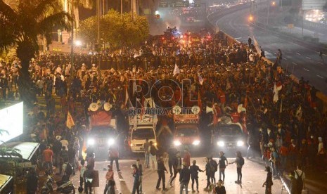 Petugas kepolisian menggunakan water canon membubarkan para pengunjuk rasa di depan Komplek Parlemen, Jakarta, Senin (17/6) malam.   (Republika/ Agung Supriyanto)