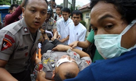  Petugas kepolisian menolong polisi yang menjadi korban bentrok antara mahasiswa dan polisi pada aksi demonstrasi di Kampus Universitas Pamulang, Pamulang, Tangerang Selatan, Kamis (19/10).   (Muhammad Iqbal/Antara)